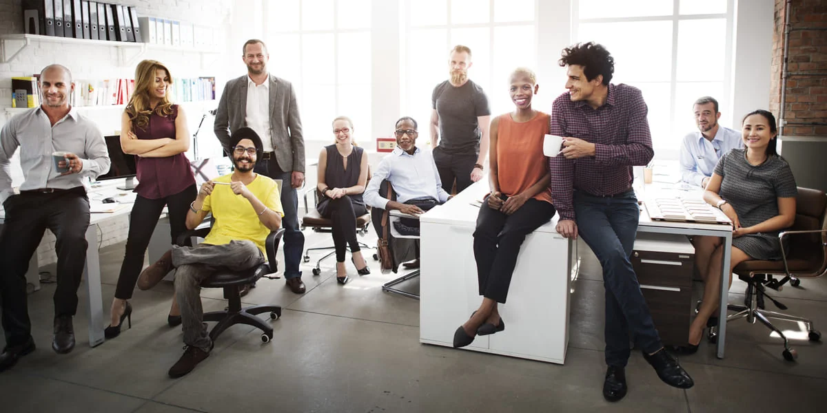 Diverse Office Team Representing Modern U.S. Workplace Rights A diverse group of office employees gathered in a bright workspace, representing inclusivity and modern workplace rights in the U.S.