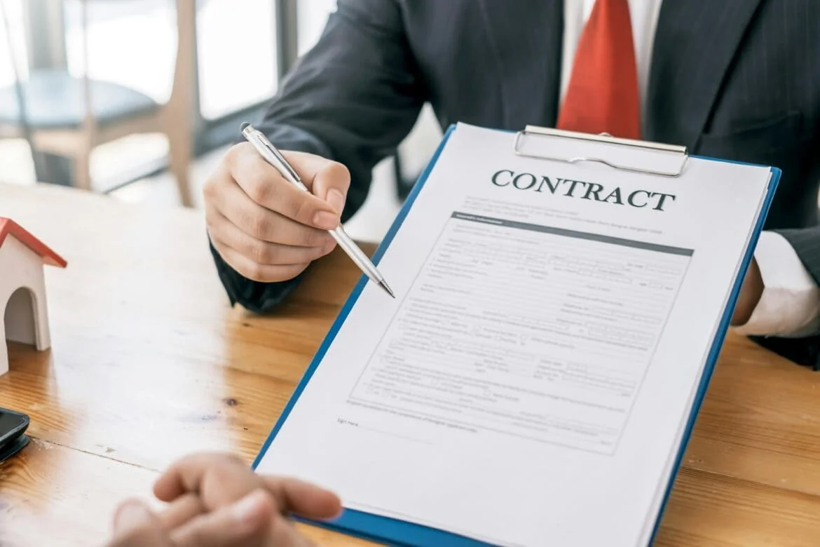 Employment Contract Termination Review Employer reviewing employment contract with pen before signing
