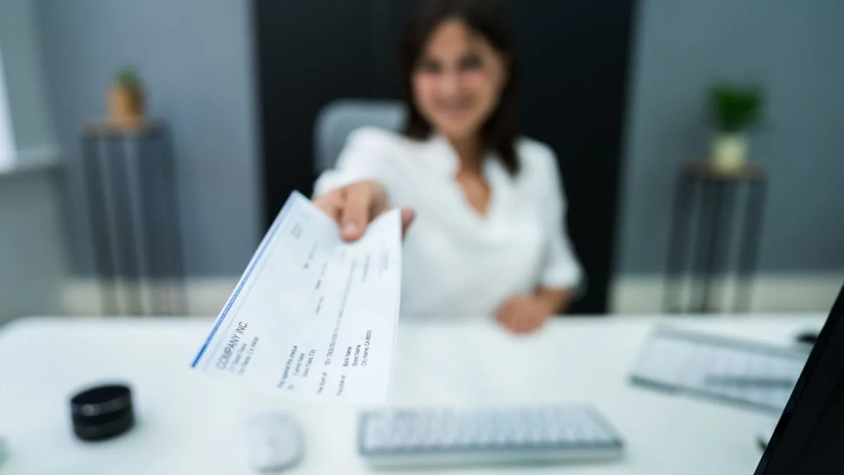 Final Paycheck After Termination Woman handing over final paycheck to terminated employee