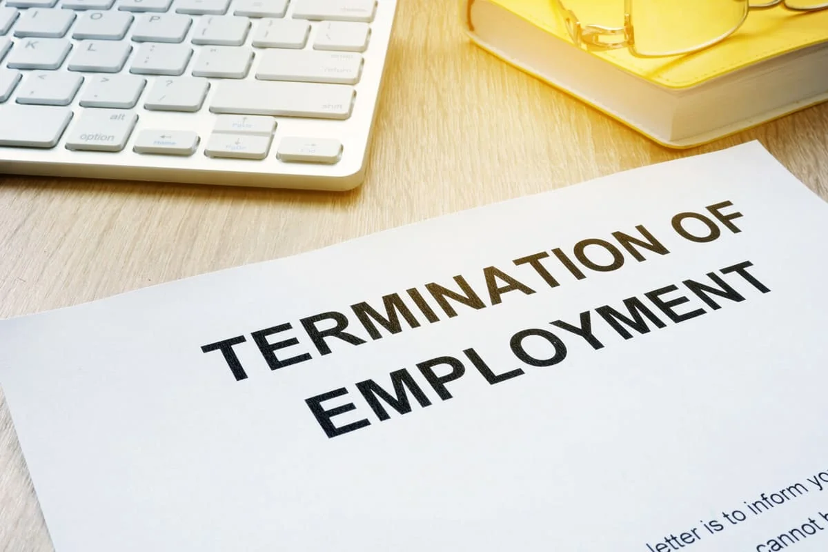 Termination of Employment Document Termination of employment notice with computer keyboard and office desk