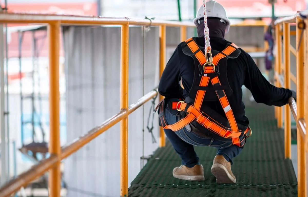 Workplace Safety Rights Under OSHA Worker wearing safety harness on construction scaffolding