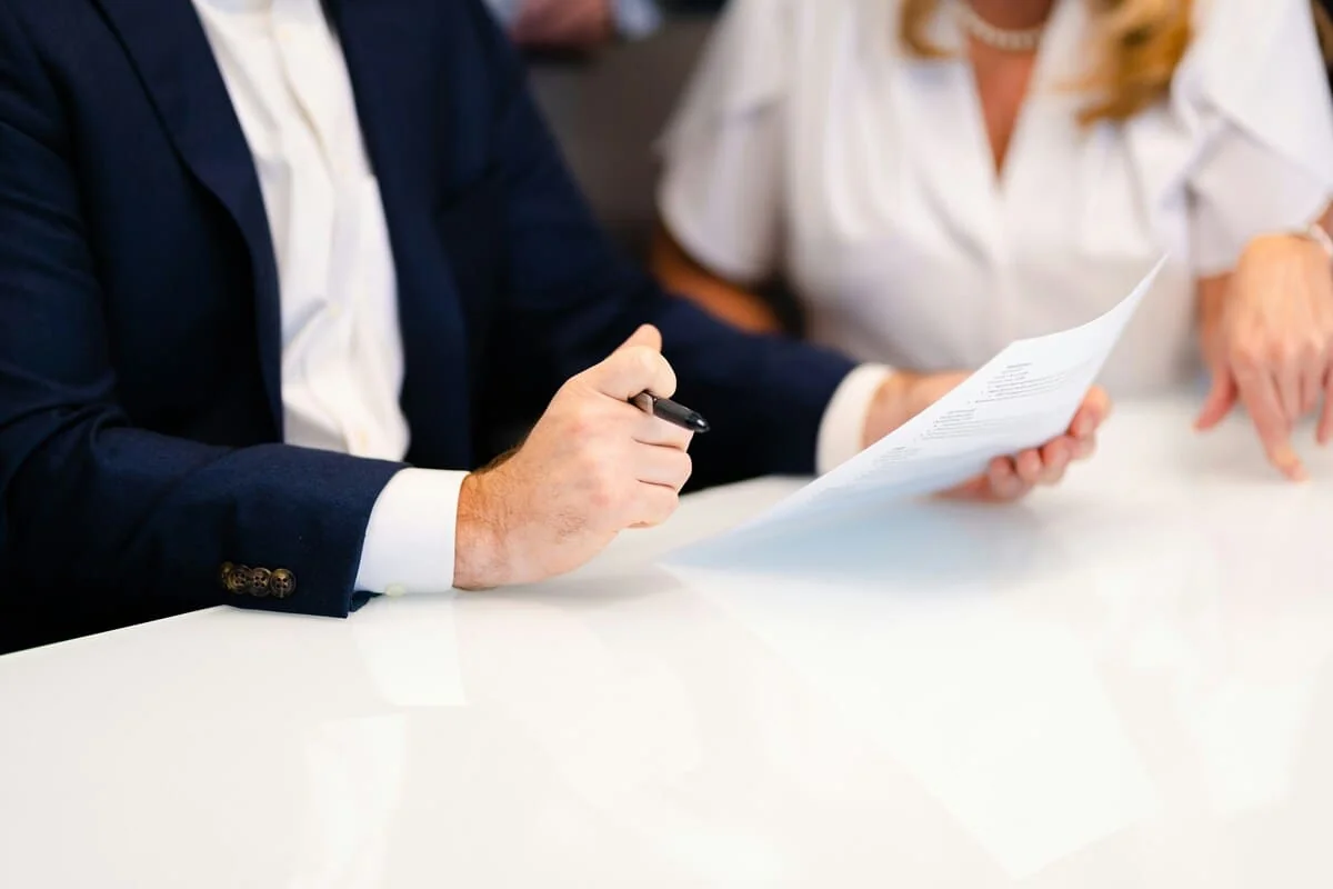 Meeting to Review Time Tracking Compliance Procedures Business professionals reviewing a time tracking compliance document during a meeting