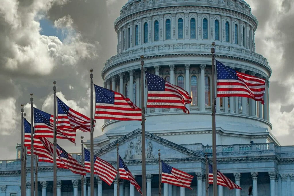 U.S. Capitol – Symbol of Federal Time Tracking Laws and Labor Compliance United States Capitol with American flags, symbolizing the federal laws governing employee time tracking and labor compliance under U.S. regulations.