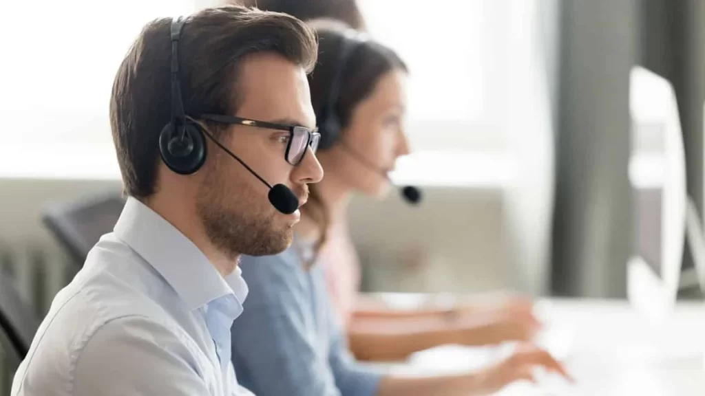 Customer service team wearing headsets working at computers