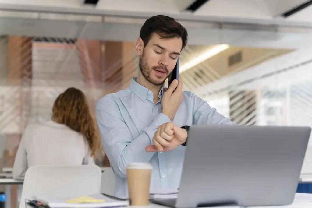 Employee checking work hours while using a laptop, showing how online time clock software fits into daily work