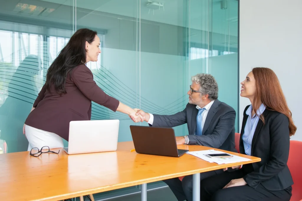 female employee giving handshake to head office in agreement of using Employee Time Clock Software