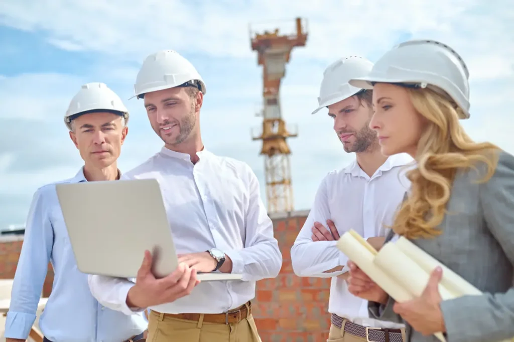 Construction team reviewing time tracking and job data on a laptop at a work site