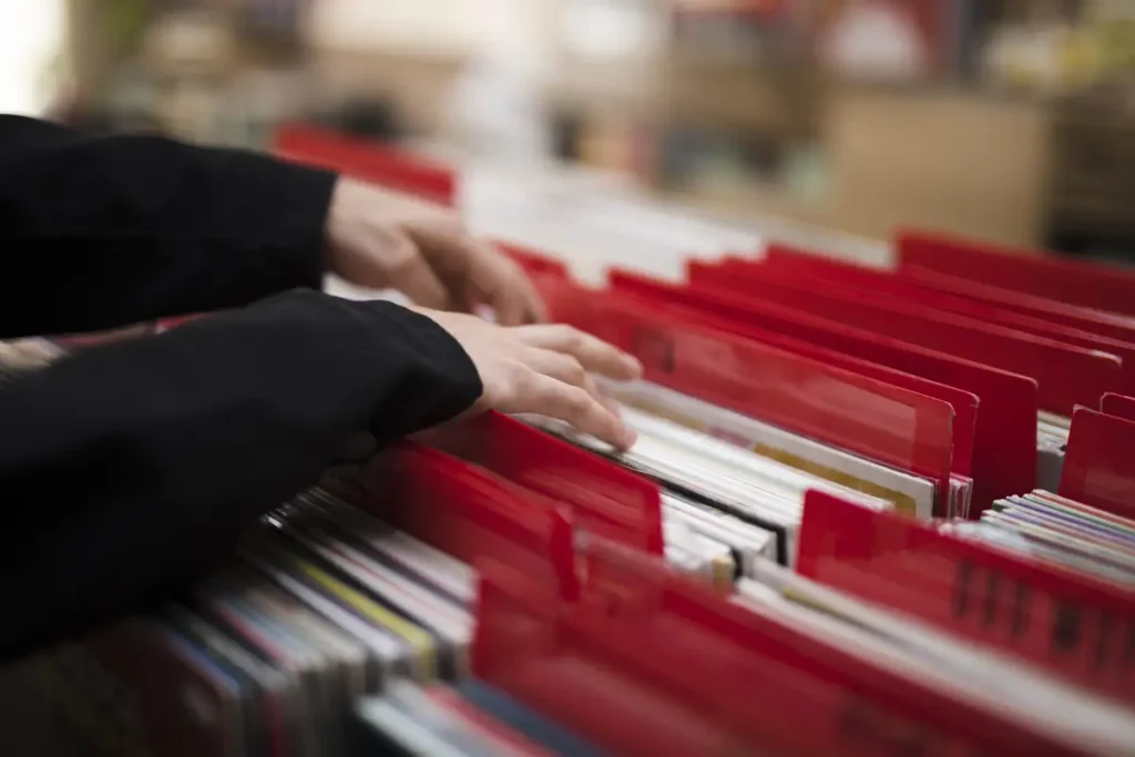 Hands organizing employee time records in filing system, representing proper payroll and record retention