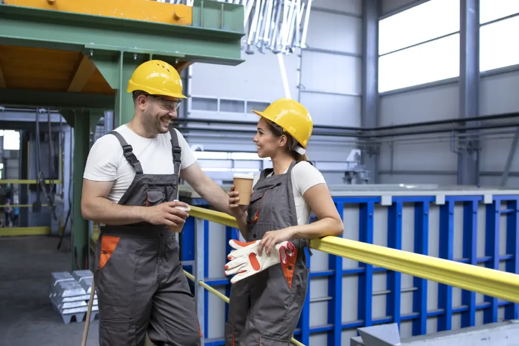 Manufacturing workers taking a break while tracking work hours in an industrial setting