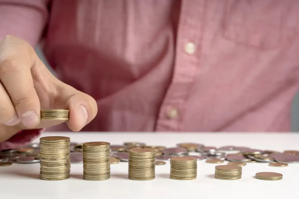 Coins stacked unevenly to represent increasing buy-once vs subscription costs for time clock software