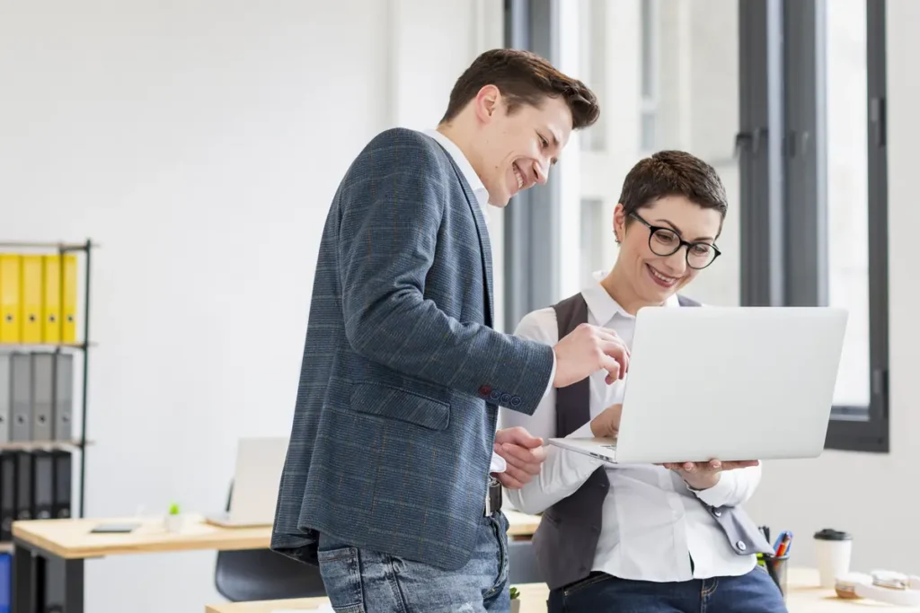 Small office team reviewing work hours together using desktop time tracking software