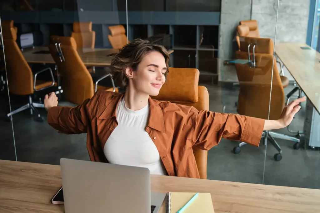 Employee stretching at a desk to stay relaxed, focused, and productive during the workday