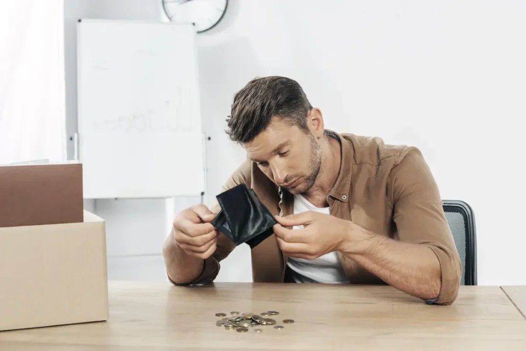 Small business owner counting coins while dealing with rising subscription costs for time tracking software