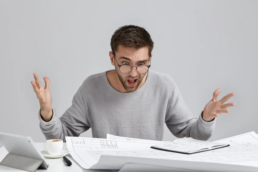 Frustrated payroll manager reviewing paperwork after discovering a decimal time conversion mistake