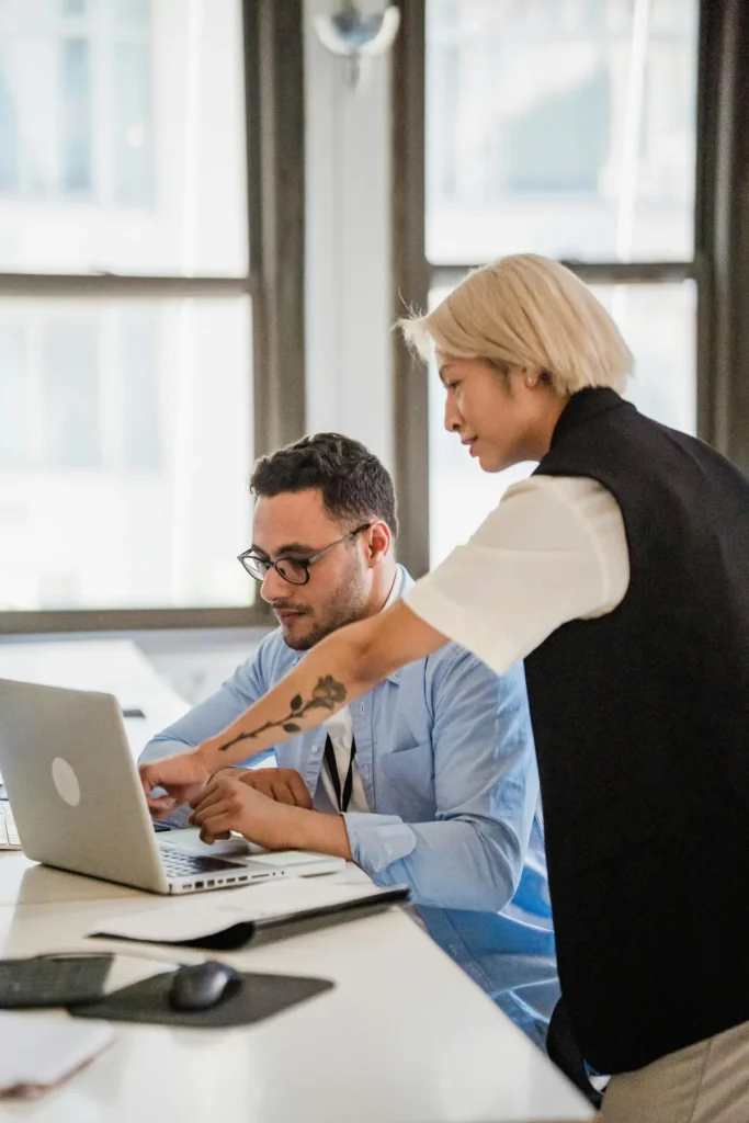 A manager and employee comparing time clock software options on a laptop
