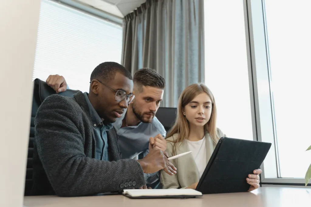 Employees gathered around a tablet, showing an easy-to-use time clock for a small team