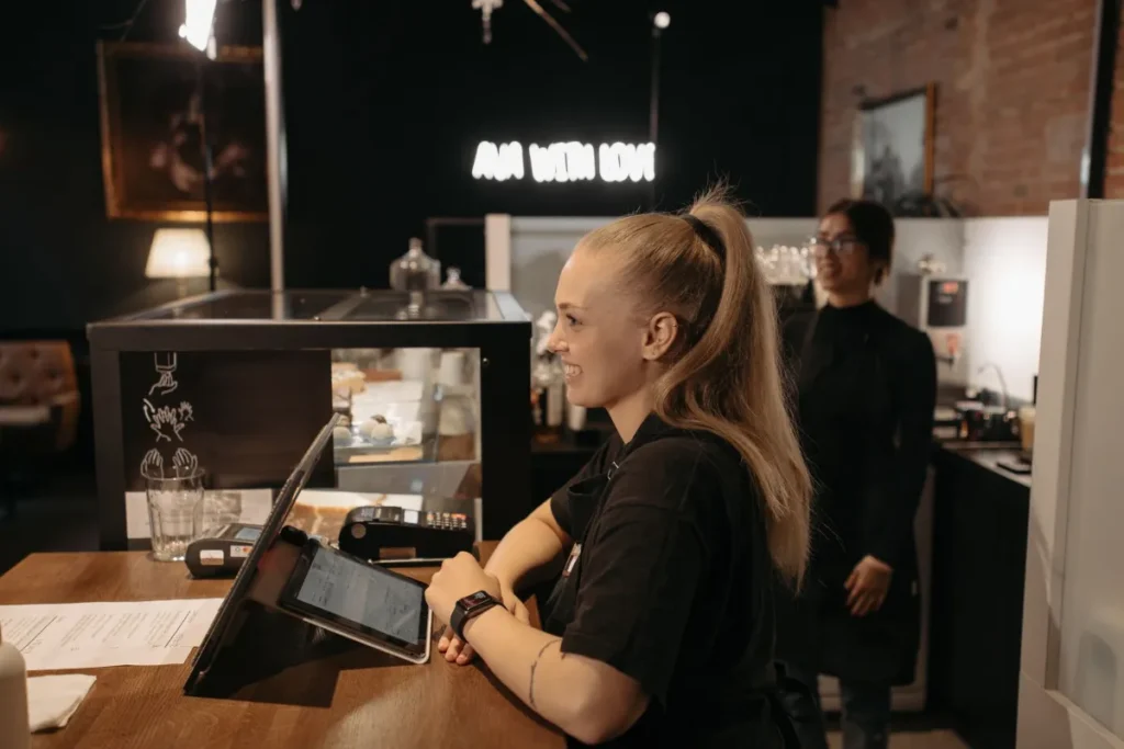 Cafe employee clocking in on a tablet at the counter
