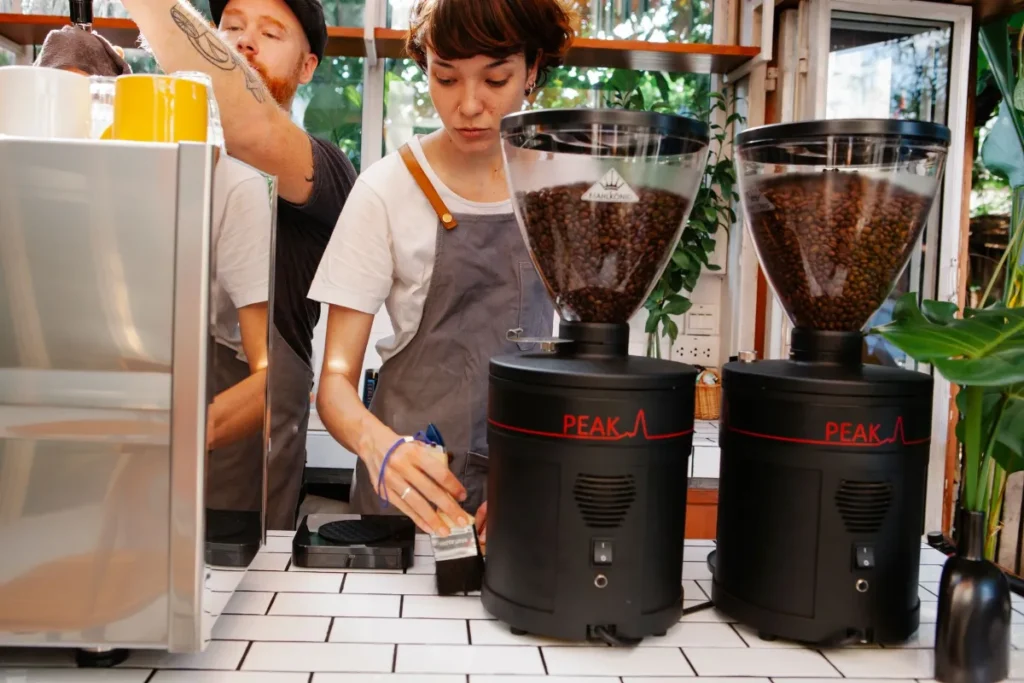Cafe employees grinding coffee behind the counter