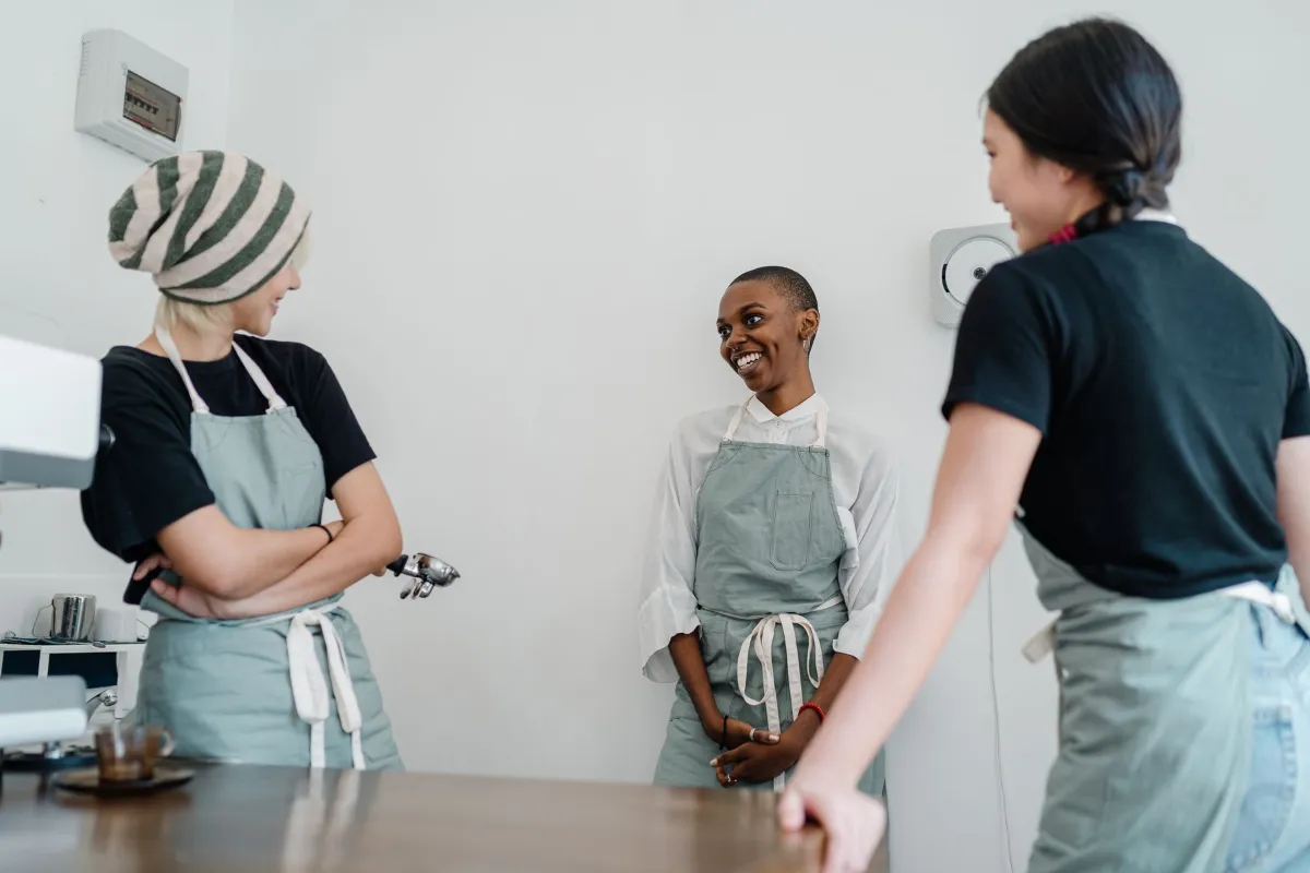 Cafe manager training two young employees