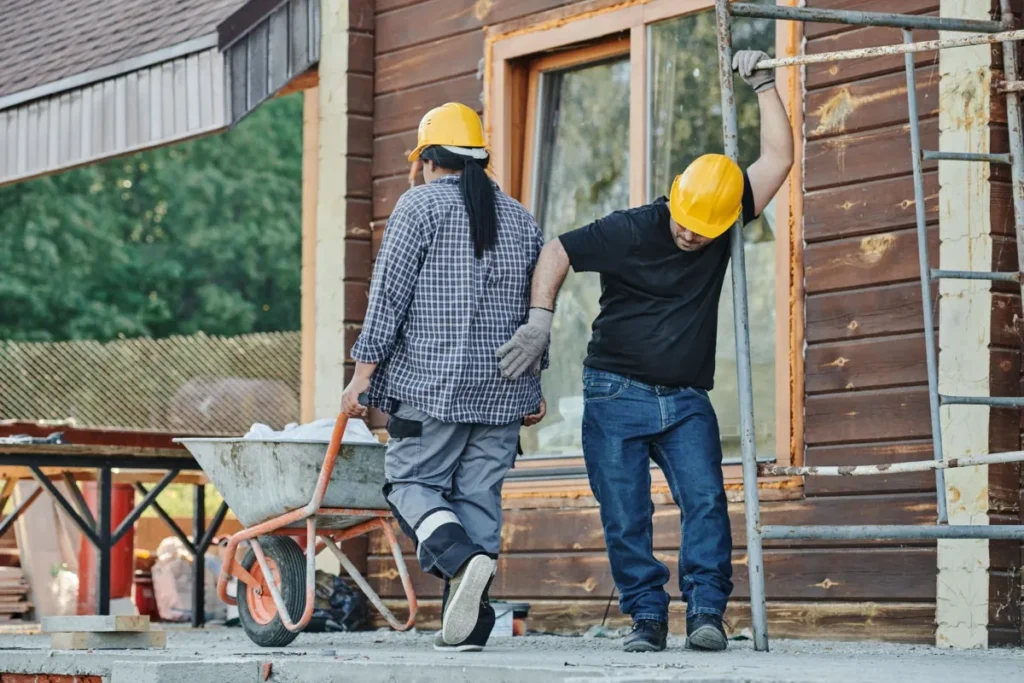 Construction workers carrying materials at a job site