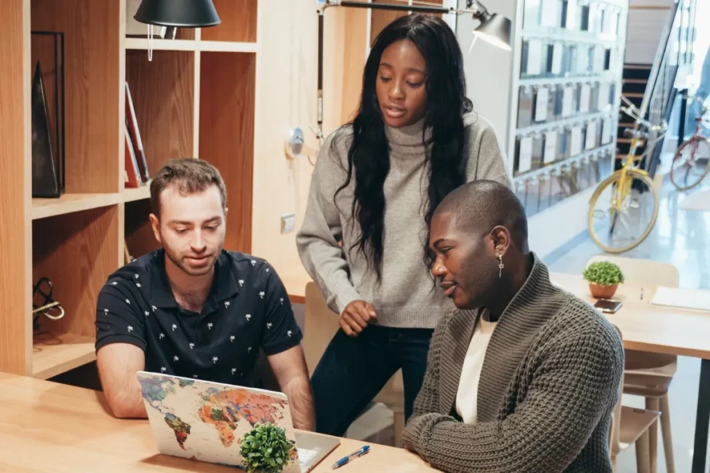 Coworkers talking at a table in a small office