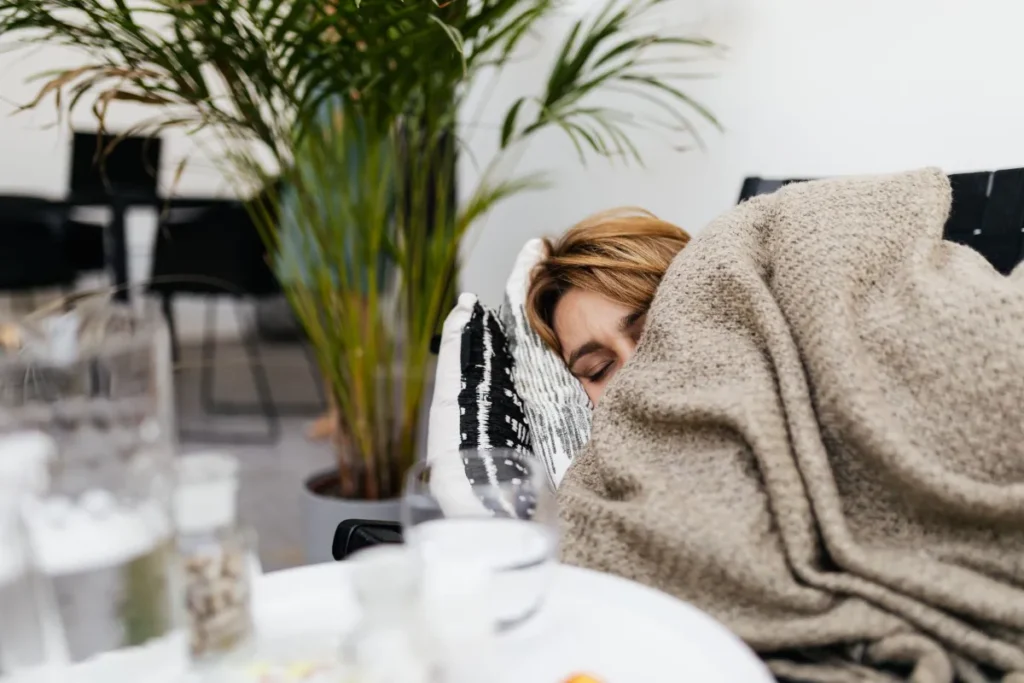 Employee home sick, resting under a blanket