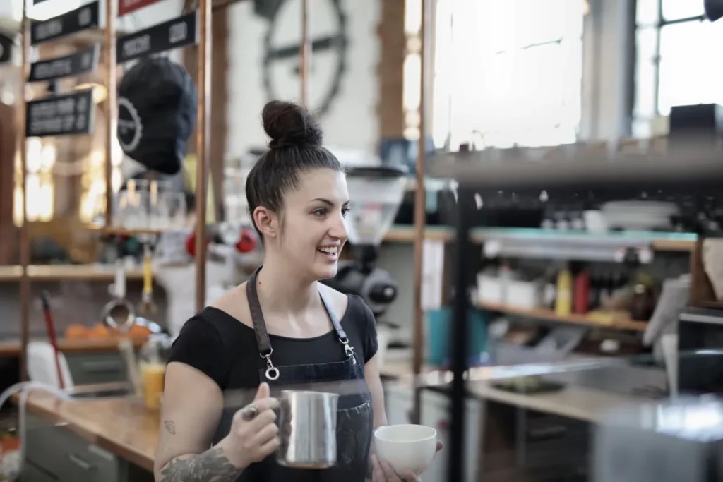 Young barista smiling while working at a coffee shop